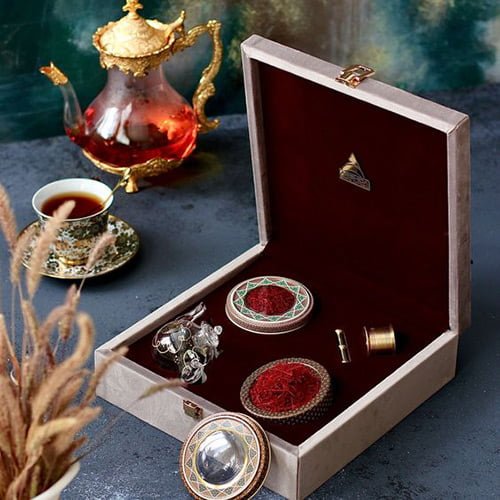 An exquisite display of Persian saffron tea in a luxurious open velvet box, with a traditional golden teapot and cup in the background, symbolizing the rich legacy and authenticity of Persian saffron. 一款精美的波斯藏红花茶展示在一个豪华的开口天鹅绒盒中，背景是传统的金色茶壶和茶杯，象征着波斯藏红花丰富的遗产和真实性。
